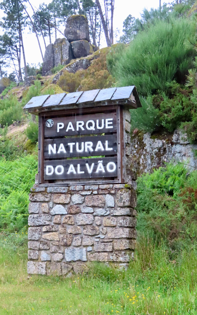 Wooden sign on rock base reading: Parque Natural do Alvao.