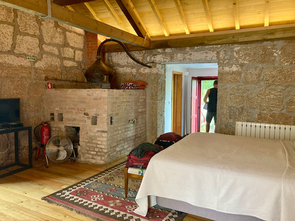 Large room with bed and brick and stone still in one corner. 