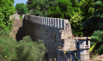 Old stone wall surrounded by green space.