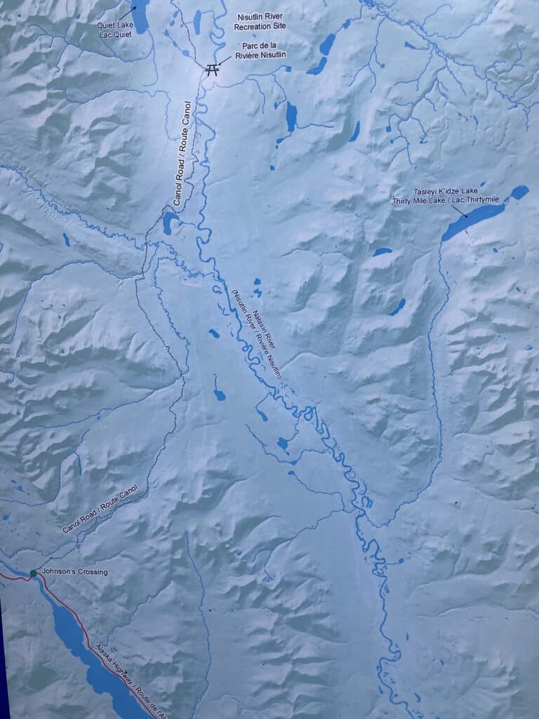 Photo of a map showing Canol Road and the winding curves of the Nisultlin River in relation to the Alaska Highway.