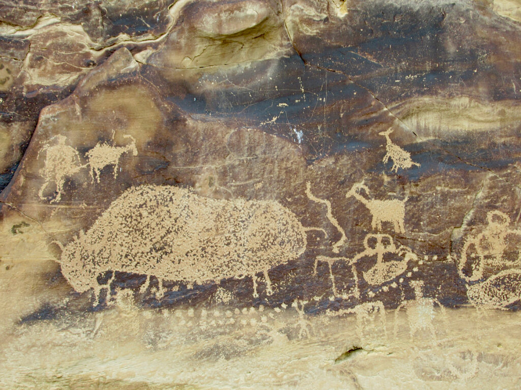 Rock art image of a big buffalo and other figures and dots.