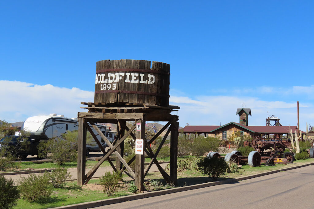 Old wooden water tower with "Goldfield 1893" painted in white letters.