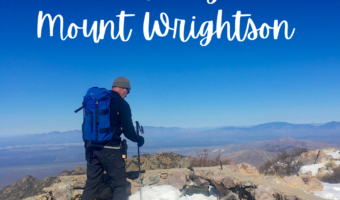 Pin image for TimeTravelTrek post reading: Travel Adventures Hiking Mount Wrightson Arizona USA TimeTravelTrek.com. White text over image of man with blue backpack hiking across a rocky and snowy peak under blue sky.