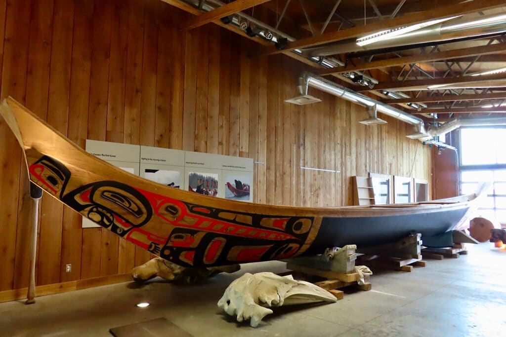 Painted red and black wooden canoe inside building.