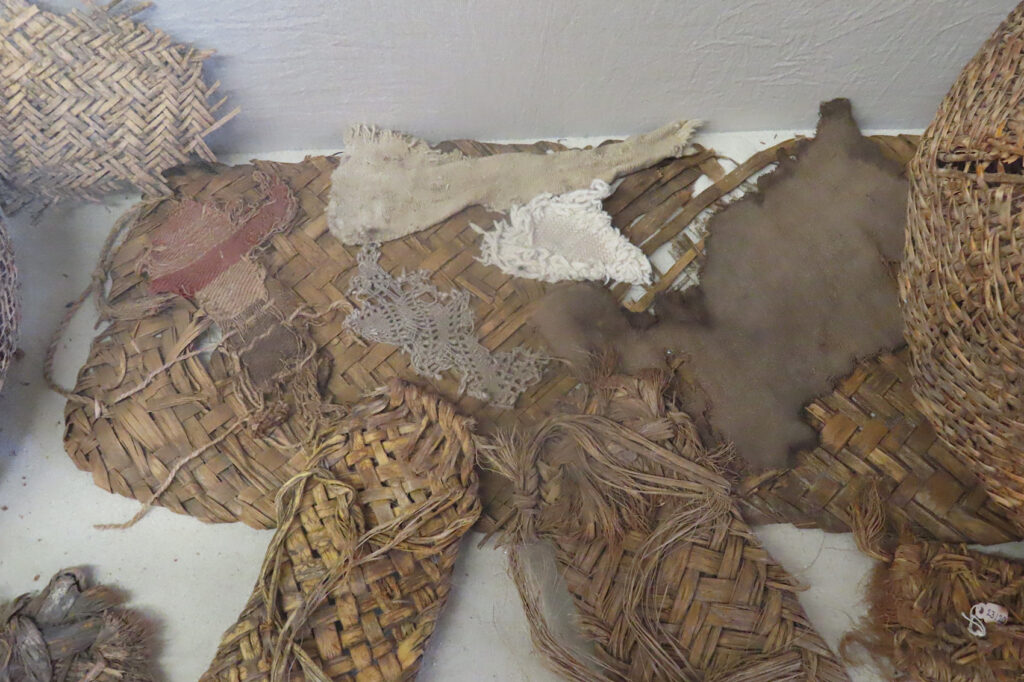 Remains of sandals woven from whole leaves and partially loosened yucca fibers in display case with other woven objects at Besh-Ba-Gowah Museum in Globe, Arizona.