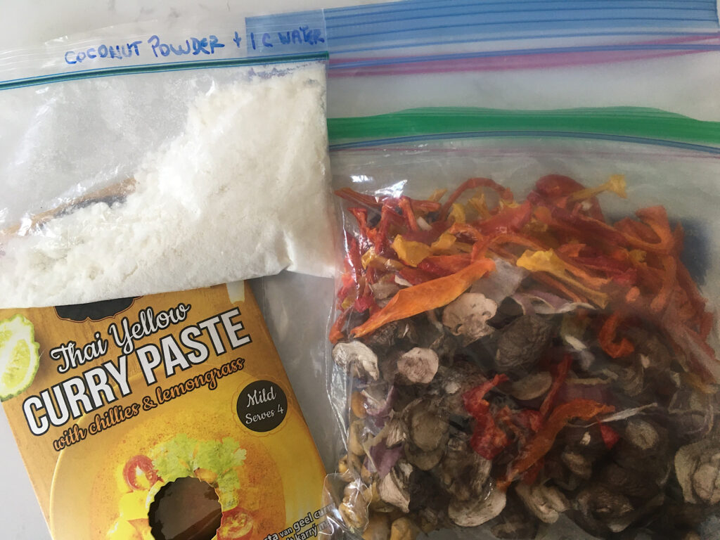 Sealing plastic bags with dried veggies, coconut milk powder and curry mix.
