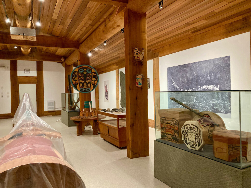 Interior of building with First Nations carvings and art.