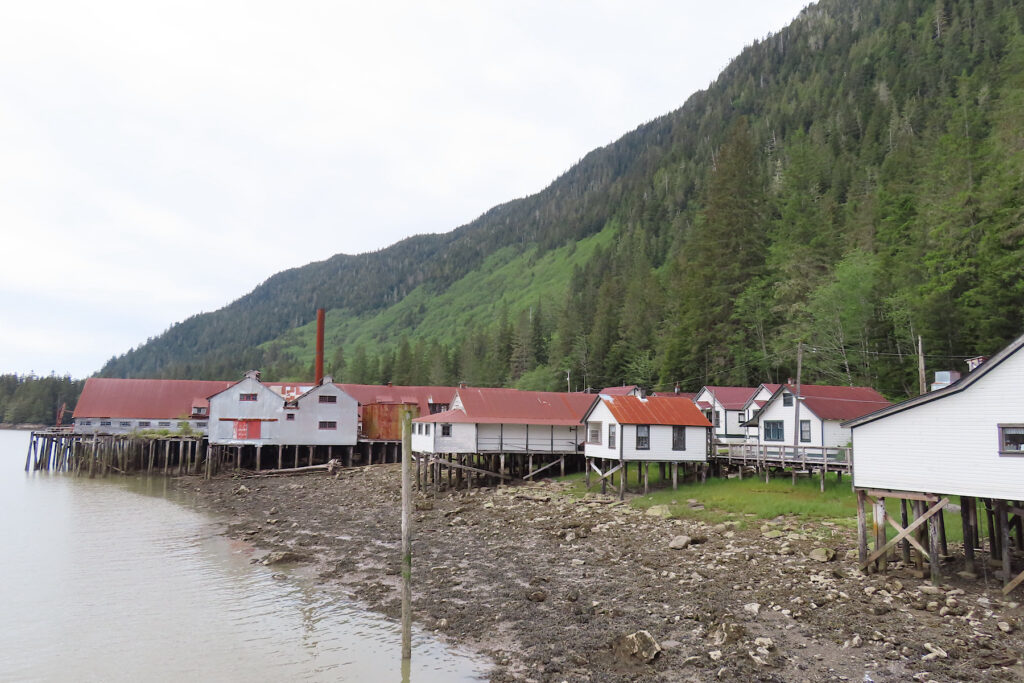 Red-roofed, white-painted buildings on stilts above water.