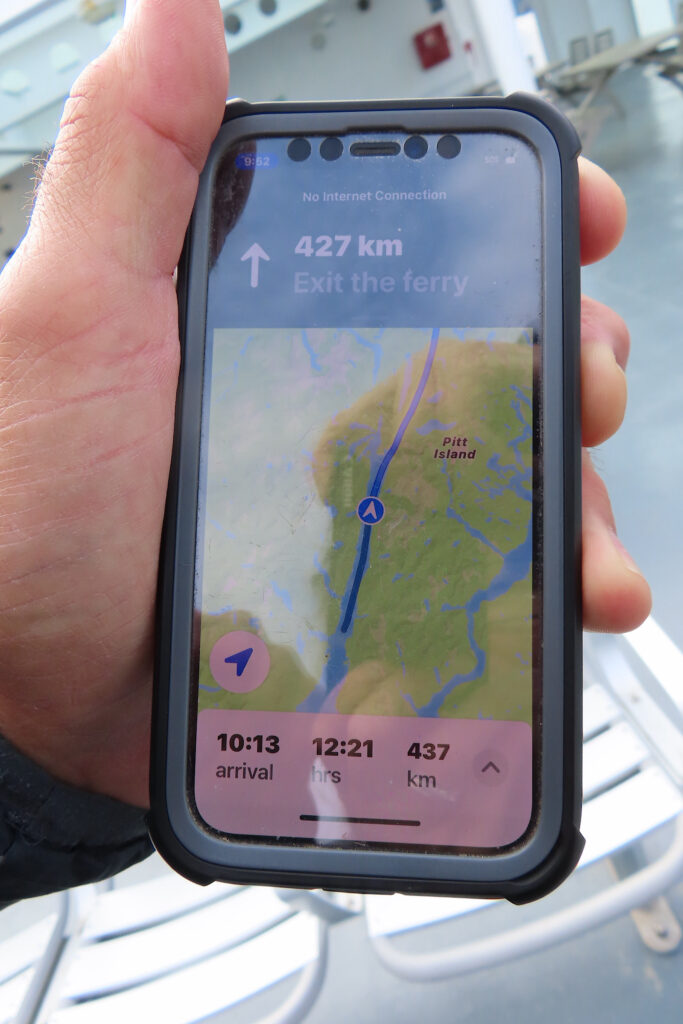 Man's hand holding cell phone with map on it.