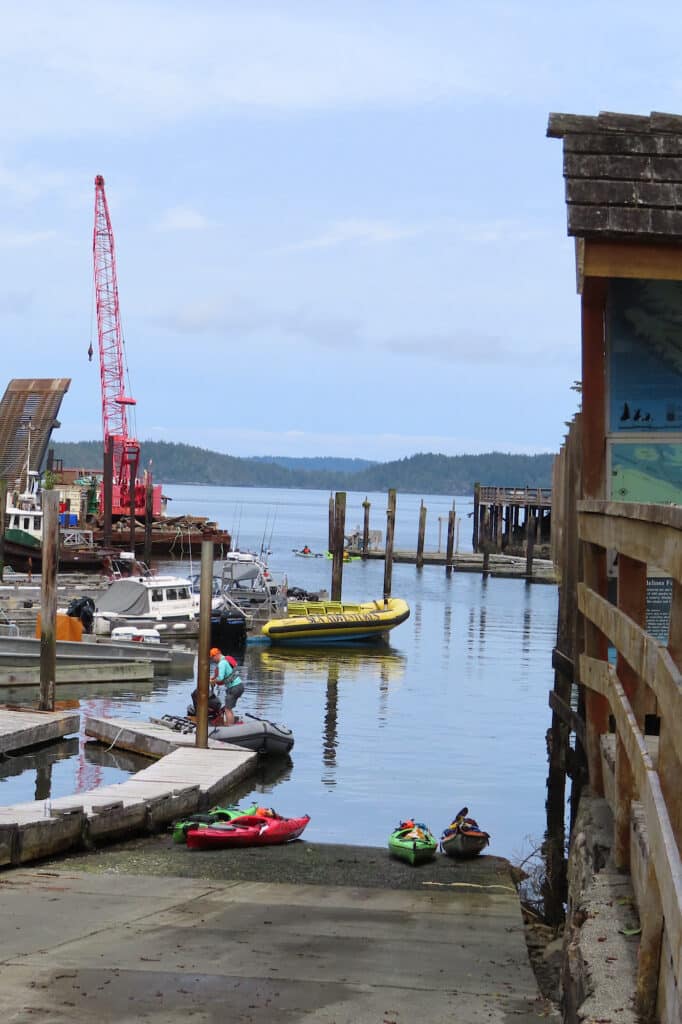 Boats and kayaks and docks in small harbour.