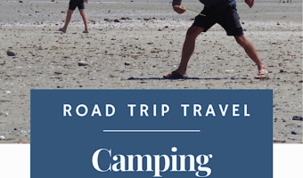 Man in shorts and shirt throwing frisbee on sandy beach