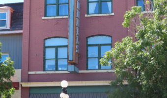 Historic red brick building with words "Dominion Land Office" written above upper windows.