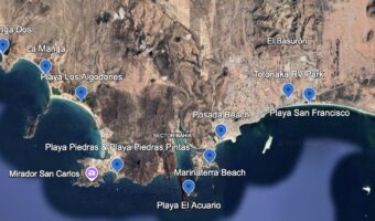 Aerial photo of land and sea with blue pins labelling beach locations.