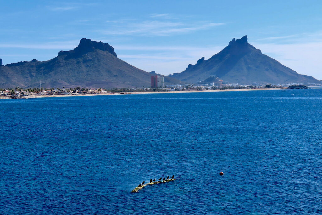 Wide open ocean with distant beach and mountains.