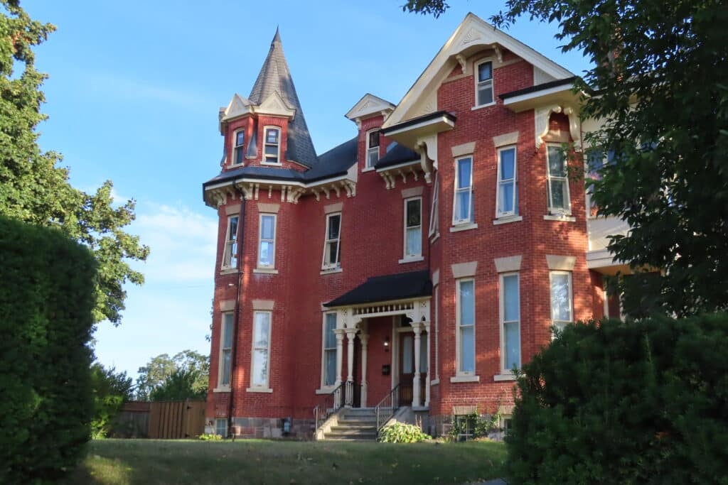 Red brick two-storey historic mansion.