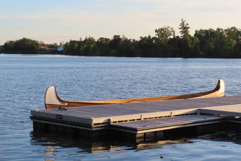 Voyageur-style canoe on water by dock.