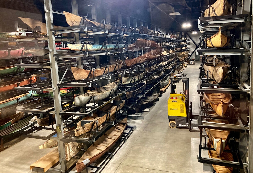 Rows of canoes in a warehouse.