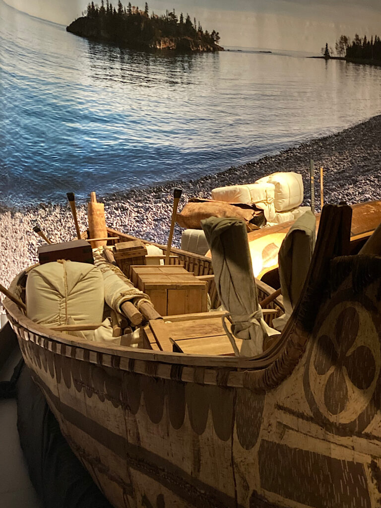 Large canoe loaded with bundles and boxes of gear.