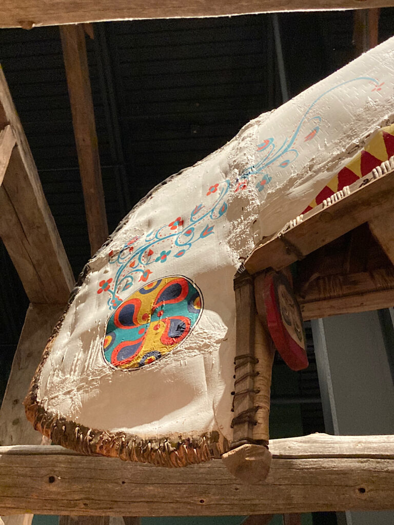 End of a canoe with painted floral design.