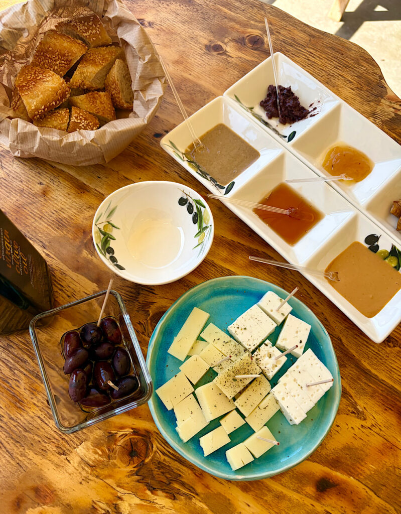 Cheese and olives and spreads and bread set out on table.