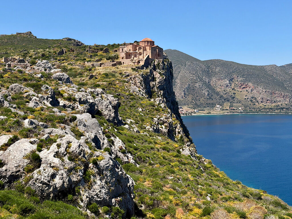 Church perched on rocky outcrop above ocean.