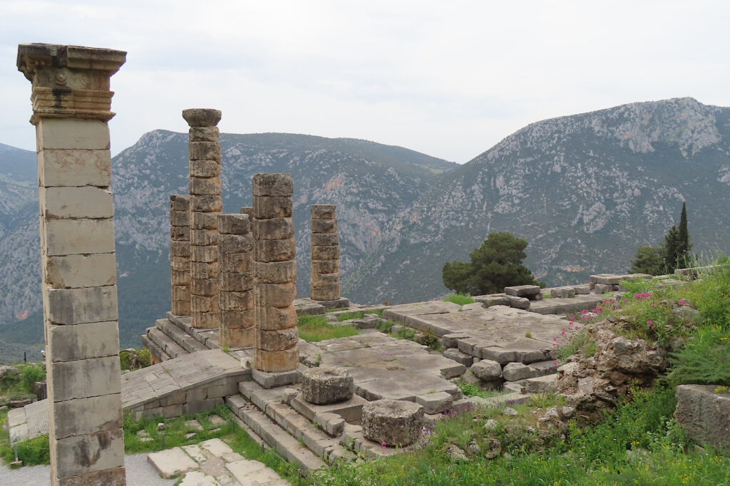 Stone ruins with pillars on steep hillside.