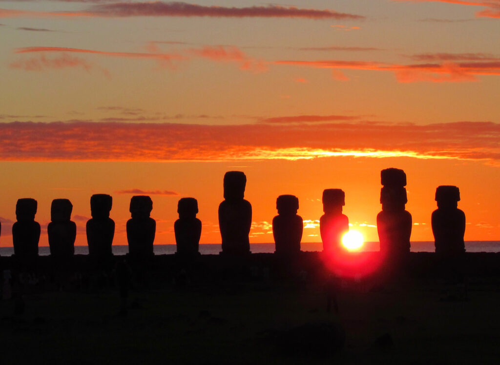 Ten silhouetted statues at sunset
